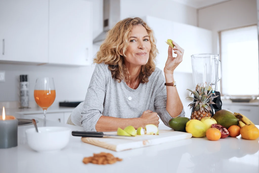 Woman eating fruit in a kitchen